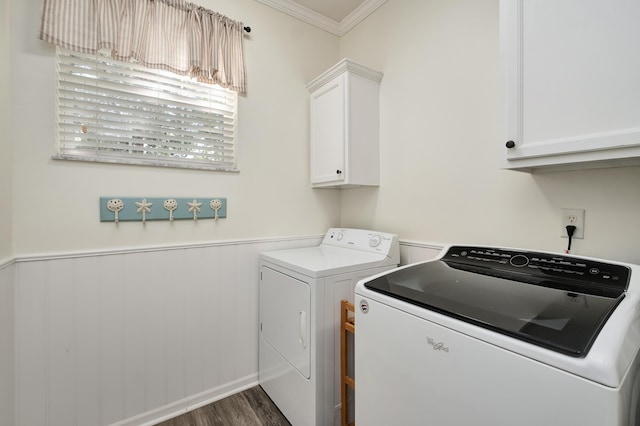 washroom featuring washing machine and clothes dryer, dark wood-type flooring, crown molding, and cabinets