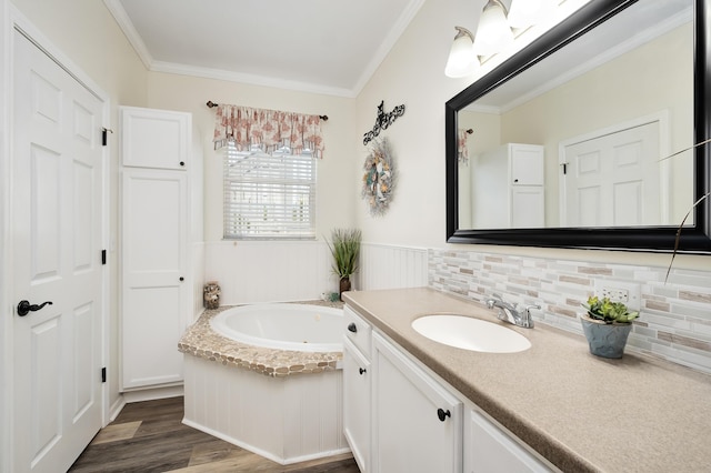 bathroom featuring hardwood / wood-style floors, crown molding, backsplash, a bathing tub, and vanity