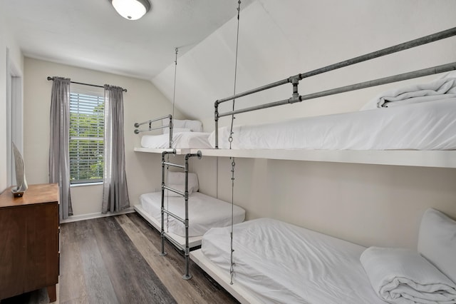 bedroom with dark hardwood / wood-style flooring and vaulted ceiling