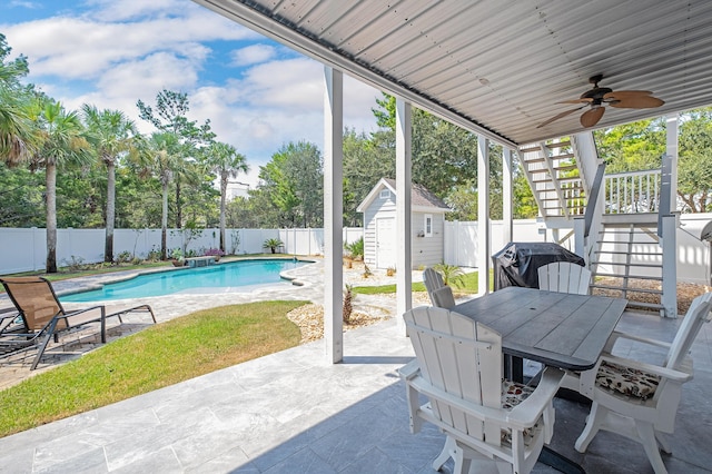 view of patio with a storage unit, ceiling fan, grilling area, and a fenced in pool