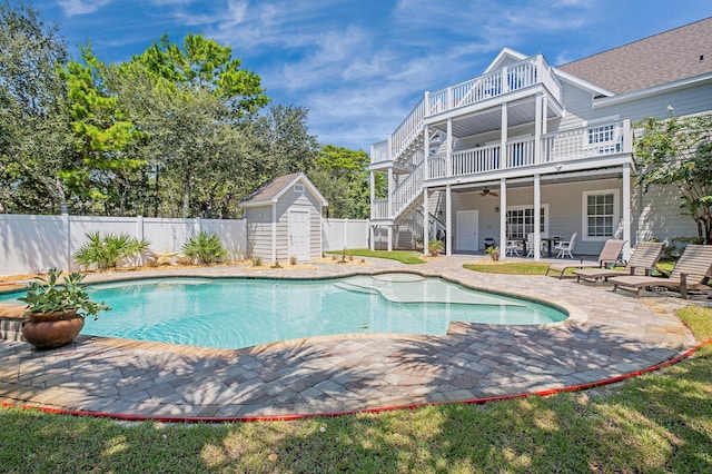 view of pool with a shed, a patio, and ceiling fan