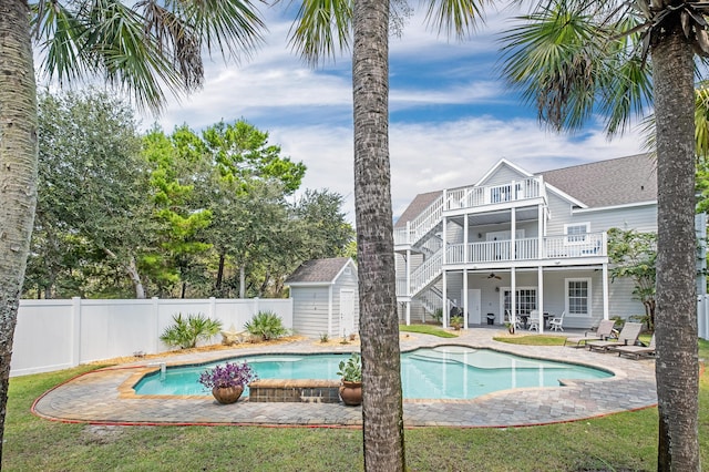 view of pool featuring a shed, ceiling fan, and a patio area