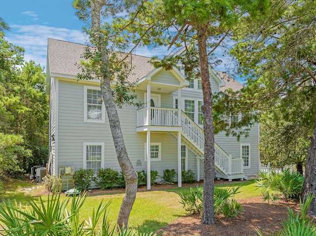 back of house with a yard, central AC, and a balcony