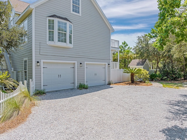 view of side of home with a garage and a balcony