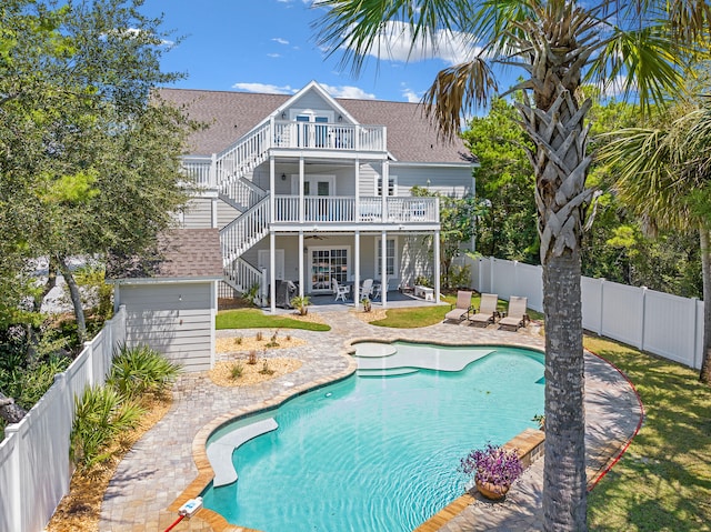 back of property featuring a balcony, a fenced in pool, and a patio area