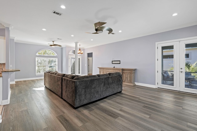 living room with ceiling fan with notable chandelier, dark hardwood / wood-style flooring, ornamental molding, and french doors