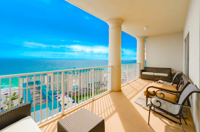 balcony featuring a view of the beach and a water view