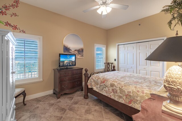 tiled bedroom featuring ceiling fan and a closet