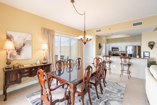 tiled dining space featuring a notable chandelier