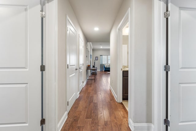 hallway featuring baseboards, dark wood-style flooring, and recessed lighting