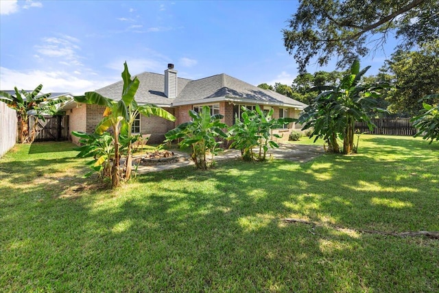 back of property featuring a yard, a fenced backyard, a patio area, and brick siding