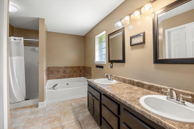 bathroom with tile patterned flooring, vanity, a textured ceiling, and independent shower and bath