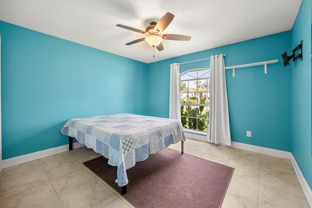 tiled bedroom with ceiling fan and a textured ceiling