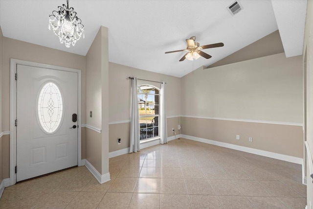 foyer featuring ceiling fan with notable chandelier, light tile patterned floors, lofted ceiling, and a wealth of natural light