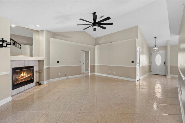 unfurnished living room with baseboards, a tiled fireplace, ceiling fan, vaulted ceiling, and light tile patterned flooring