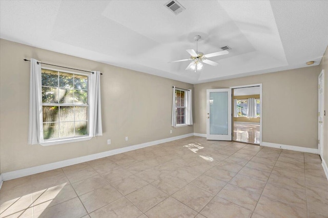 unfurnished room with a tray ceiling, ceiling fan, and french doors