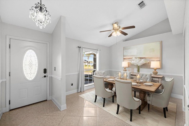 tiled dining room featuring ceiling fan with notable chandelier, a wealth of natural light, and lofted ceiling