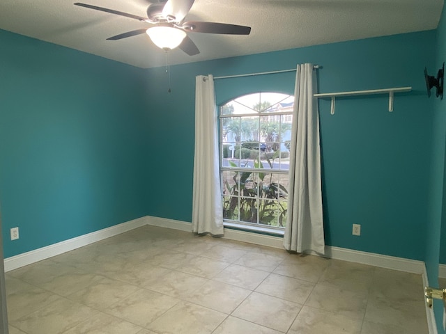 empty room with a textured ceiling and ceiling fan