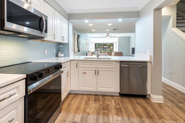 kitchen featuring white cabinets, light wood-type flooring, kitchen peninsula, and stainless steel appliances