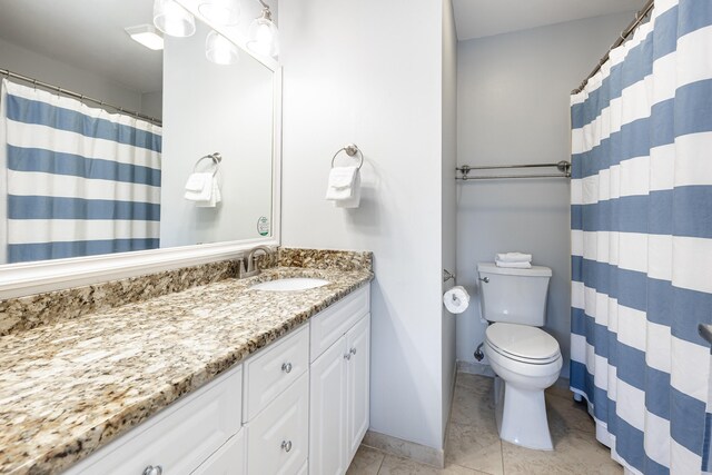 bathroom featuring tile patterned flooring, a shower with curtain, vanity, and toilet