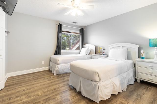 bedroom featuring hardwood / wood-style floors, a textured ceiling, and ceiling fan