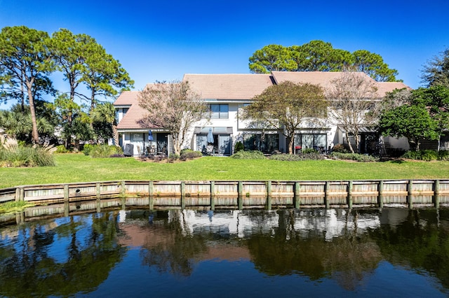 rear view of property featuring a yard and a water view