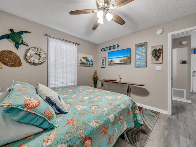 bedroom featuring a textured ceiling, ceiling fan, and hardwood / wood-style flooring