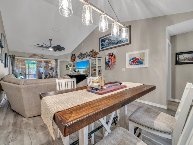 dining area with hardwood / wood-style flooring, vaulted ceiling, and ceiling fan