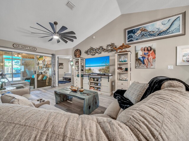 living room featuring light hardwood / wood-style floors, vaulted ceiling, and ceiling fan