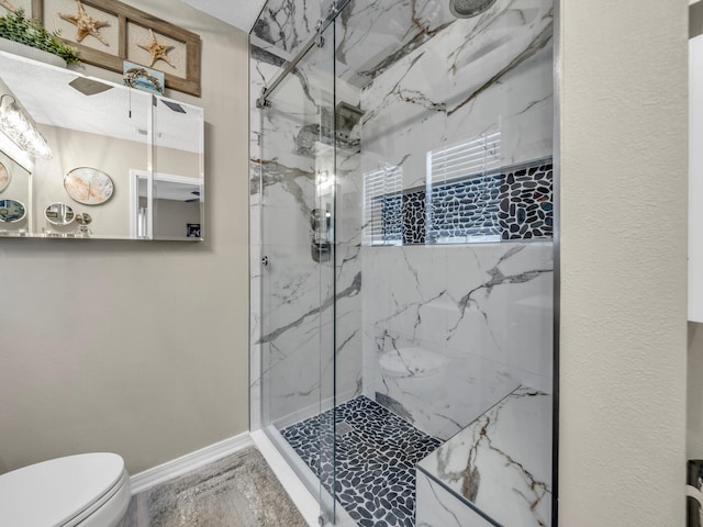 bathroom featuring toilet and a shower with shower door