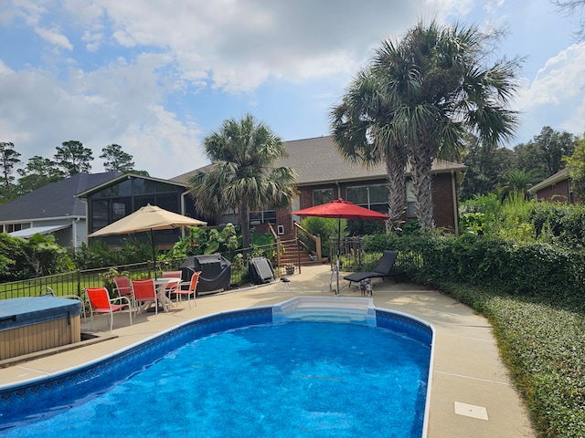 view of swimming pool featuring a grill, a hot tub, and a patio area