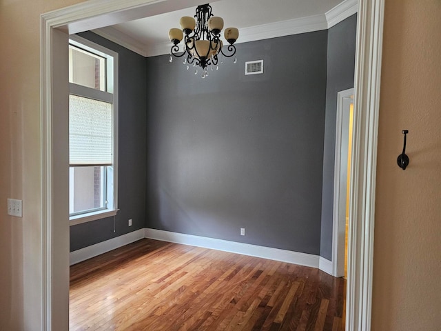 unfurnished room with wood-type flooring, a chandelier, and crown molding