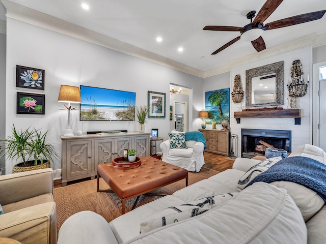 living room featuring ceiling fan, recessed lighting, a fireplace, wood finished floors, and ornamental molding