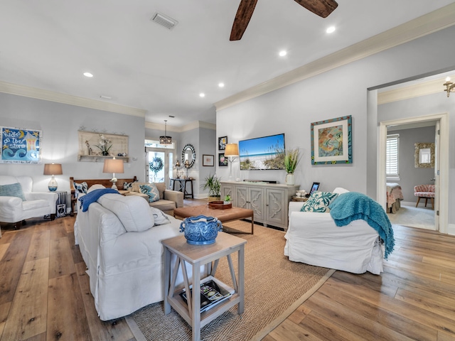 living area featuring recessed lighting, visible vents, crown molding, and hardwood / wood-style floors