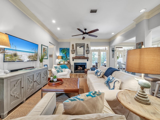 living area with ornamental molding, a fireplace, visible vents, and recessed lighting