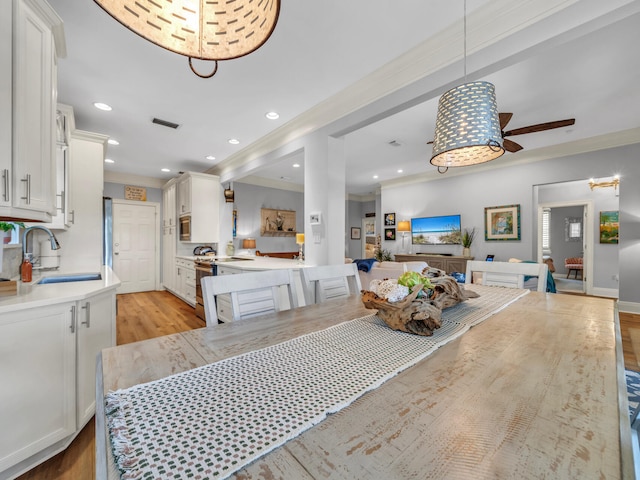 dining area with ornamental molding, light wood-type flooring, visible vents, and recessed lighting