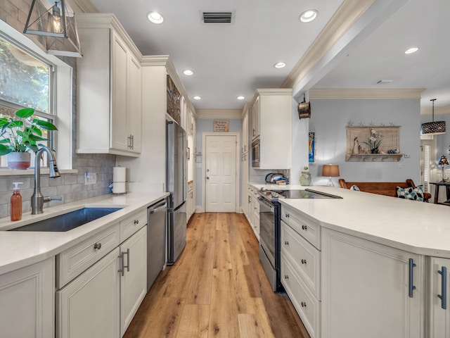 kitchen with stainless steel appliances, light countertops, visible vents, and a sink