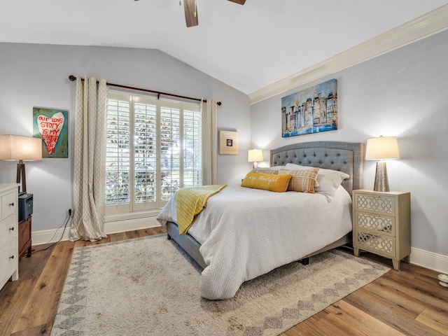 bedroom featuring a ceiling fan, lofted ceiling, baseboards, and wood finished floors