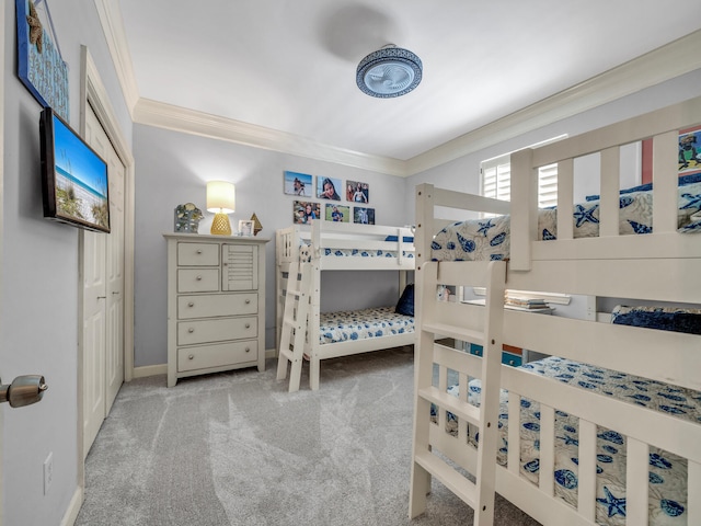 carpeted bedroom featuring crown molding and baseboards