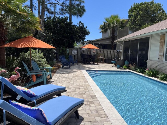 view of pool featuring a patio and a sunroom