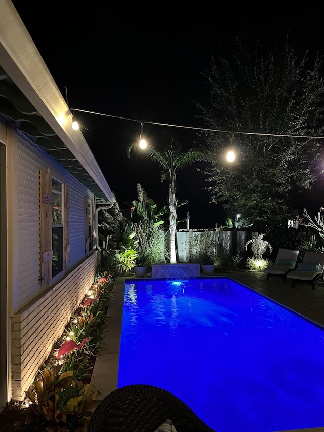 pool at twilight with fence and a fenced in pool