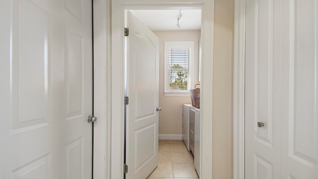 laundry area with washing machine and dryer and light tile patterned floors