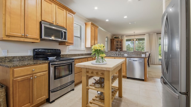 kitchen featuring light tile patterned flooring, appliances with stainless steel finishes, sink, and kitchen peninsula