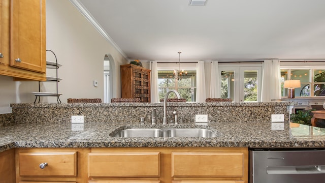 kitchen featuring sink, dark stone countertops, a chandelier, dishwasher, and crown molding