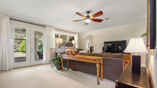 carpeted living room featuring ceiling fan, crown molding, and french doors