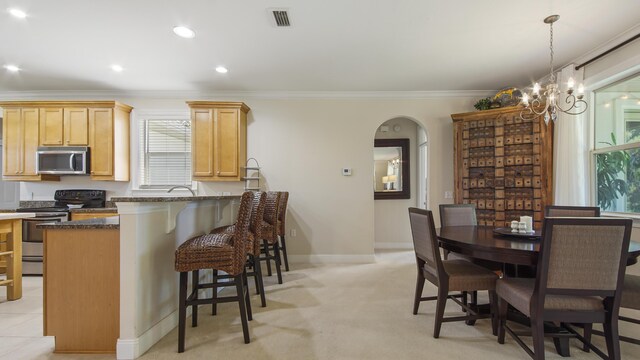 dining room with a wealth of natural light, light carpet, a notable chandelier, and crown molding