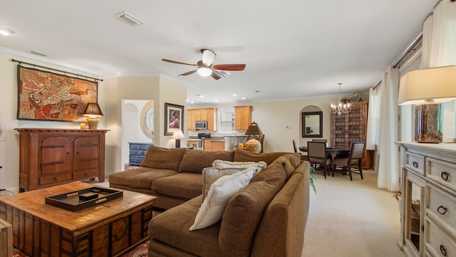 living room with crown molding, ceiling fan with notable chandelier, and light colored carpet