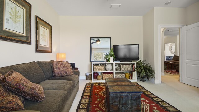 living room with ceiling fan and carpet flooring