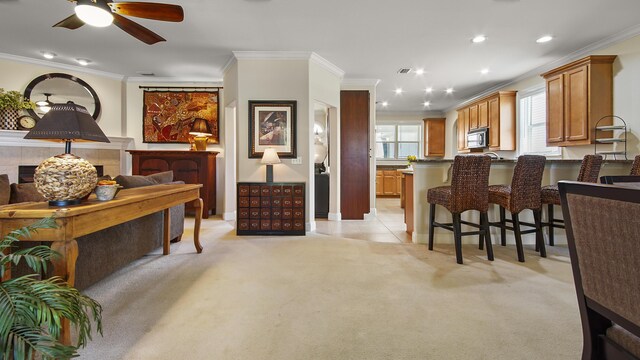 kitchen with ceiling fan, ornamental molding, and light carpet