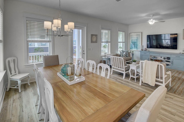 dining area featuring ceiling fan with notable chandelier and light wood-type flooring